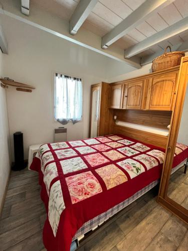 - une chambre avec un lit doté d'une couette rouge et blanche dans l'établissement Belle maison de vacances semi climatisée, clôturée, véranda, 6 couchages, résidence LE VILLAGE DE LA MER LRVM93, à Portiragnes