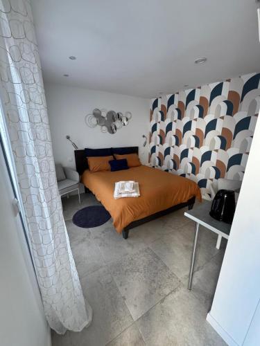 une chambre avec un lit avec un couvre-lit orange dans l'établissement Villa Elimia piscine privée & chauffée, à Antibes