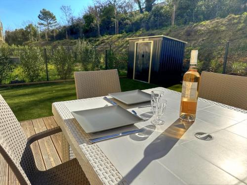 a table with a bottle of wine and a glass at Appartement cozy avec jacuzzi privé, Brignoles in Brignoles
