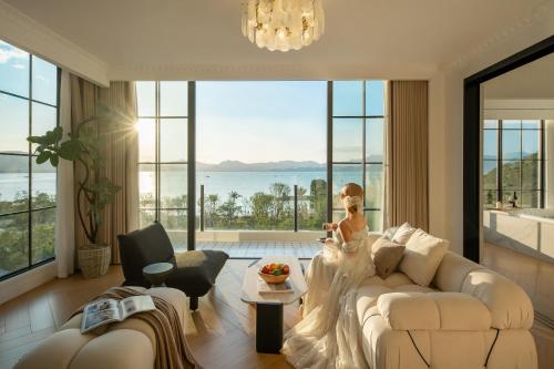a living room with a white couch and large windows at Mello Hotel in Shenzhen