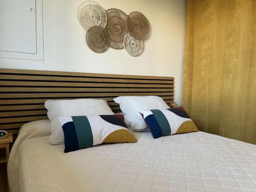 - une chambre avec un lit avec deux chapeaux sur le mur dans l'établissement SP820-021 appartement T2 cabine - 4 couchages Saint Pierre la Mer, à Saint Pierre La Mer