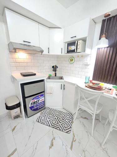 a white kitchen with a sink and a table at Steff's Condo 722 at Centrio Tower in Cagayan de Oro