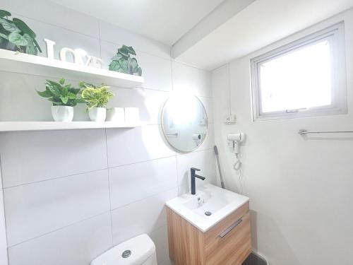 a white bathroom with a sink and a mirror at Steff's Condo 722 at Centrio Tower in Cagayan de Oro