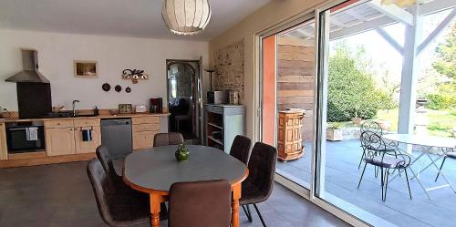 a kitchen and dining room with a table and chairs at Le Reflet du Trèfle in Puybegon