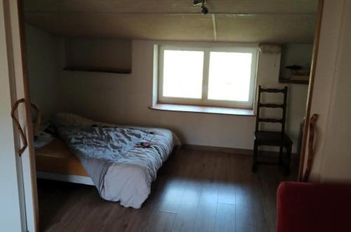 a small bedroom with a bed and a window at Casa de l'Aberg' in LʼAbergement-de-Varey