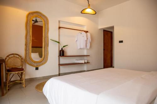 a bedroom with a white bed and a mirror at Alma Boutique Hostel - Colombo in Colombo