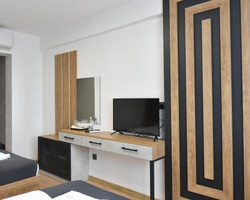 a bedroom with a tv on a desk with a bed at Danchev Hotel in Slivo Pole