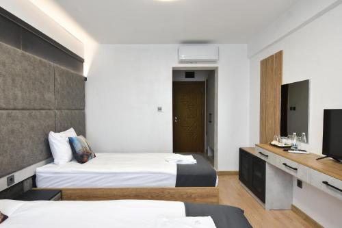 a hotel room with two beds and a tv at Danchev Hotel in Slivo Pole