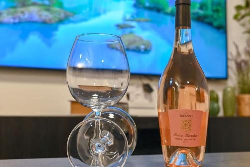 a wine glass sitting next to a bottle of wine at Loft Hagalil in Tiberias