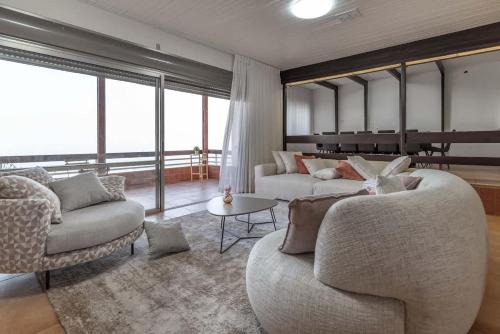 a living room with two couches and a piano at Kinneret View Six Bedrooms in Tiberias