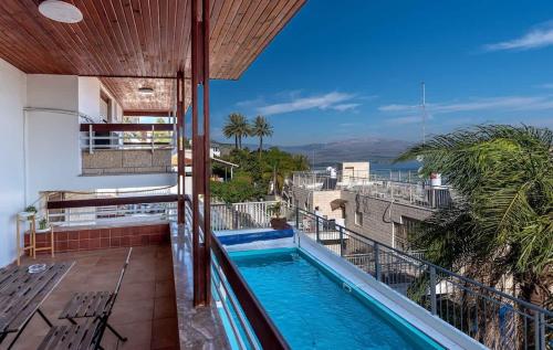 a balcony with a swimming pool on top of a building at Kinneret View Six Bedrooms in Tiberias