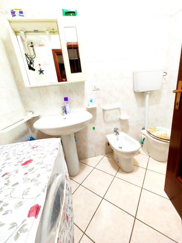 a bathroom with a sink and a toilet and a mirror at Gamm Simius Home Holiday in Villasimius