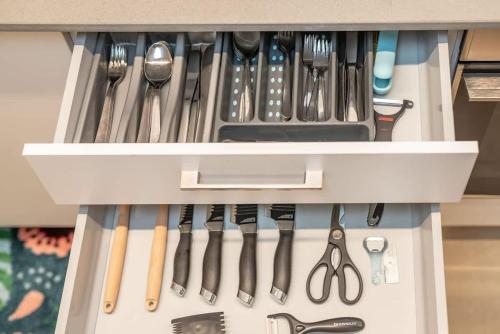 a drawer filled with lots of cooking utensils at Michaelangelo Luxury Garden Apartment with Private Pool in Tiberias