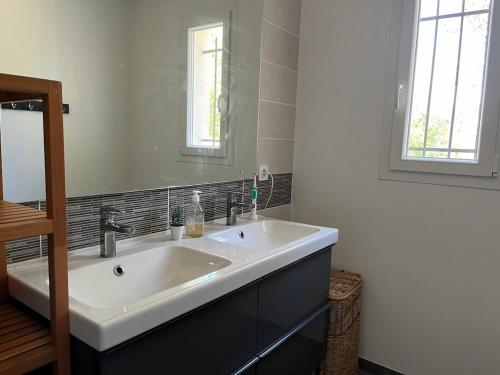 a bathroom with a white sink and a mirror at Paisible villa avec piscine proche du Pic Saint-Loup in Saint-Jean-de-Cuculles