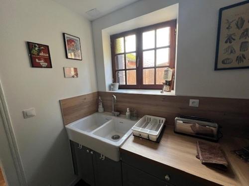 une salle de bain avec un lavabo et une fenêtre dans l'établissement La Parenthèse en bord de seine, à Muids