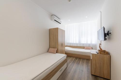 a small bedroom with a bed and a tv at E-home Apartments in Varna City