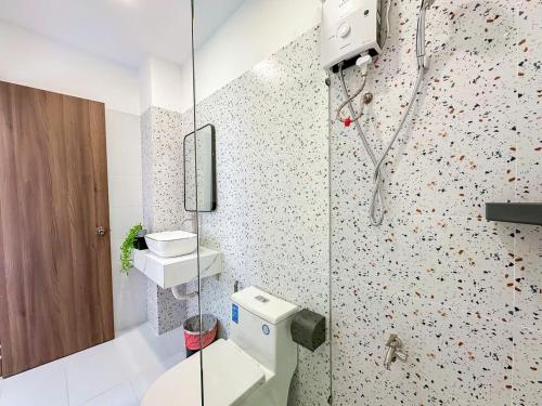 a bathroom with a toilet and a glass shower at The Cozy Nest in Ho Chi Minh City