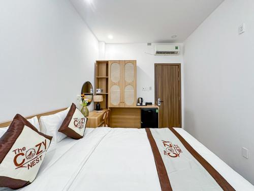 a bedroom with a white bed and a desk at The Cozy Nest in Ho Chi Minh City