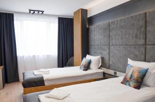 a hotel room with two beds and a window at Danchev Hotel in Slivo Pole