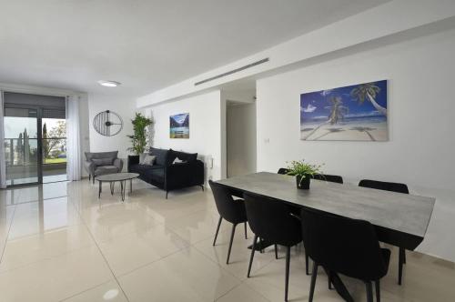 Ariston First Line Lake View في طبرية: غرفة طعام وغرفة معيشة مع طاولة وكراسي