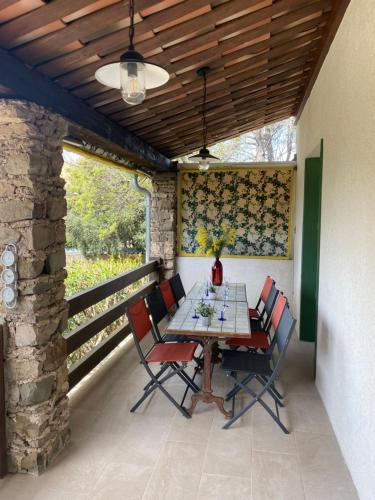 une table et des chaises assises sur un porche avec un plafond dans l'établissement Belle villa avec piscine FRENCH RIVIERA - Quartier Tour de Mare, à Fréjus