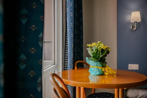 a table with a vase of flowers on it at Hotel Lilia in Golden Sands