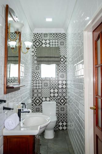 a bathroom with a white toilet and a sink at Iso'Bella Vita Guesthouse in Phalaborwa