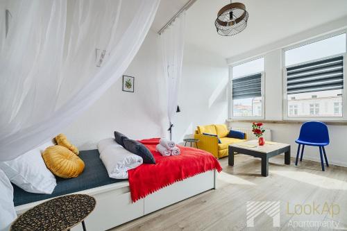 a bedroom with a bed with a red blanket at Piotrkowska pasaż Schillera by LookAp in Łódź