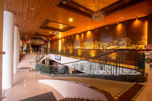a lobby with a staircase in a building at Thong Tarin Hotel in Surin