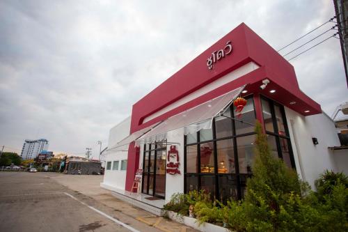 a store front with a red and white building at Thong Tarin Hotel in Surin