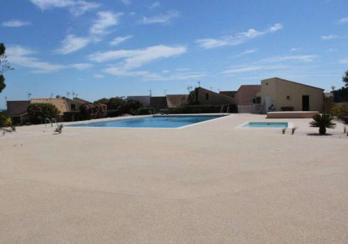 une grande piscine vide dans une cour dans l'établissement SP310-013 Maison studio mezzanine 4 couchages SAINT PIERRE LA MER, à Saint Pierre La Mer