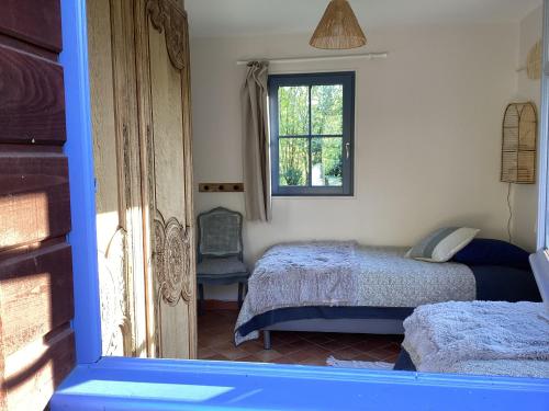 a bedroom with two beds and a window at Maison campagne rivière forêt in Le Brévedent