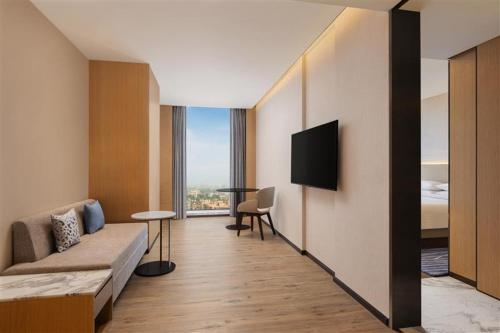 a hotel room with a couch and a tv at Courtyard by Marriott Ranchi in Rānchī
