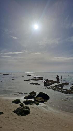 a group of people standing on the beach at וילה ביפו קרוב לנמל יפו והעיר העתיקה in Tel Aviv