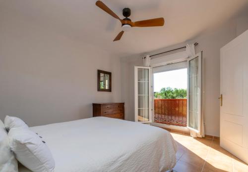 een witte slaapkamer met een bed en een raam bij apartamento campo de golf Isla Canela in Isla Canela