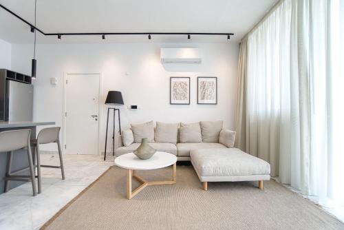 a living room with a couch and a table at Prestige 401 2 BED in Paphos