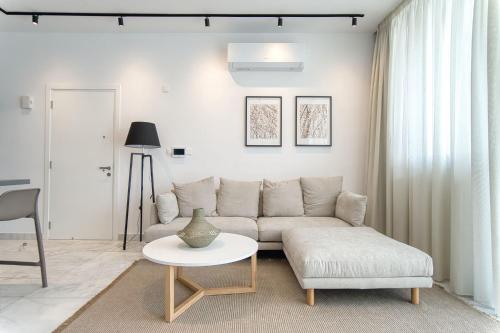 a living room with a couch and a table at Prestige 401 2 BED in Paphos