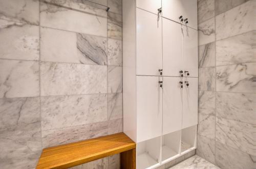 a bathroom with white marble walls and a walk in shower at Prestige 401 2 BED in Paphos