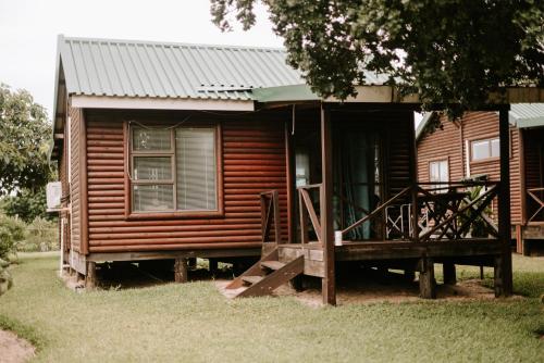 a wooden cabin with a porch in front of it at Cabins Sodwana Bay - antibootika in Sodwana Bay