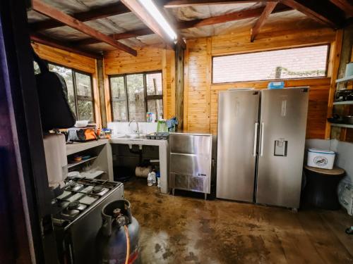 a kitchen with a stainless steel refrigerator and a sink at Cabins Sodwana Bay - antibootika in Sodwana Bay