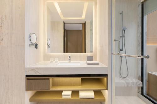 a bathroom with a sink and a shower at Courtyard by Marriott Ranchi in Rānchī