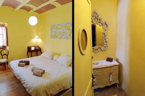 a yellow bedroom with a bed and a mirror at Masia Can Sisó in Crespiá