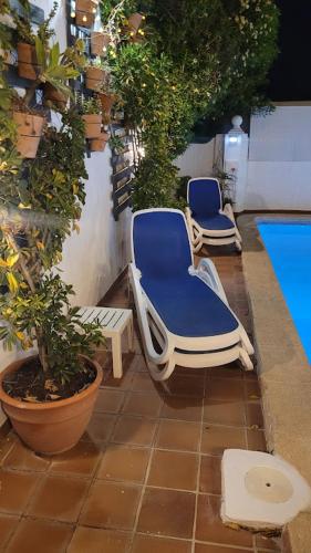 two blue chairs sitting on a patio next to a pool at ADOSADO DE LUJO CON PISCINA PRIVADA en ZONA MUY TRANQUILA in Gandía