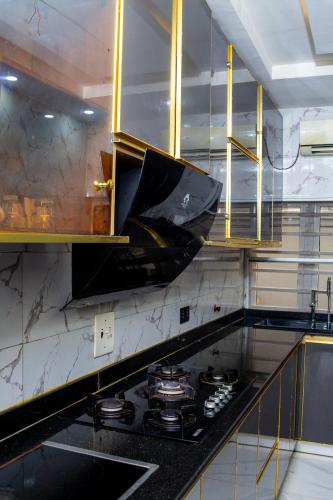 una cucina con un piano di lavoro nero e una stufa di Fola's House a Lagos
