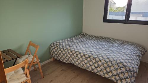 une chambre avec un lit, une chaise et une fenêtre dans l'établissement Chambre privée 350 m de la mer et proche et gr34 avec coin repas et micro onde, à Plouguerneau
