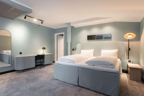 a bedroom with a large white bed and a desk at Scandic Oslo City in Oslo