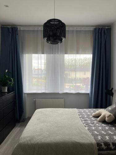 a bedroom with a bed with blue curtains and a window at Apartment Mountain Blue in Sigulda