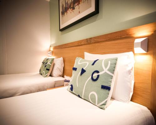 a hotel room with two beds and a pillow at The Dolby Hotel Liverpool - Free city centre parking in Liverpool