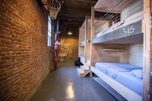 a room with bunk beds and a brick wall at PodShare DTLA in Los Angeles