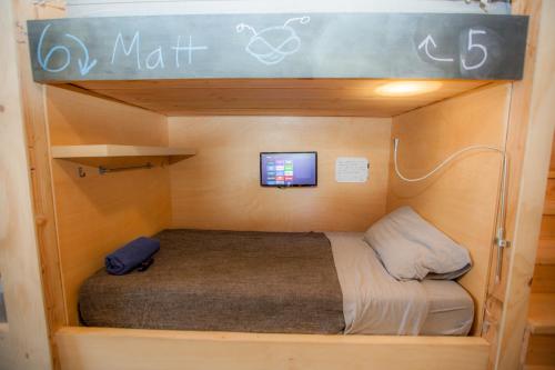 a bunk bed in a small room with a tv at PodShare DTLA in Los Angeles